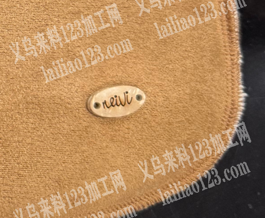 这个标牌缝在麂皮绒布料上面，机器钉标外发